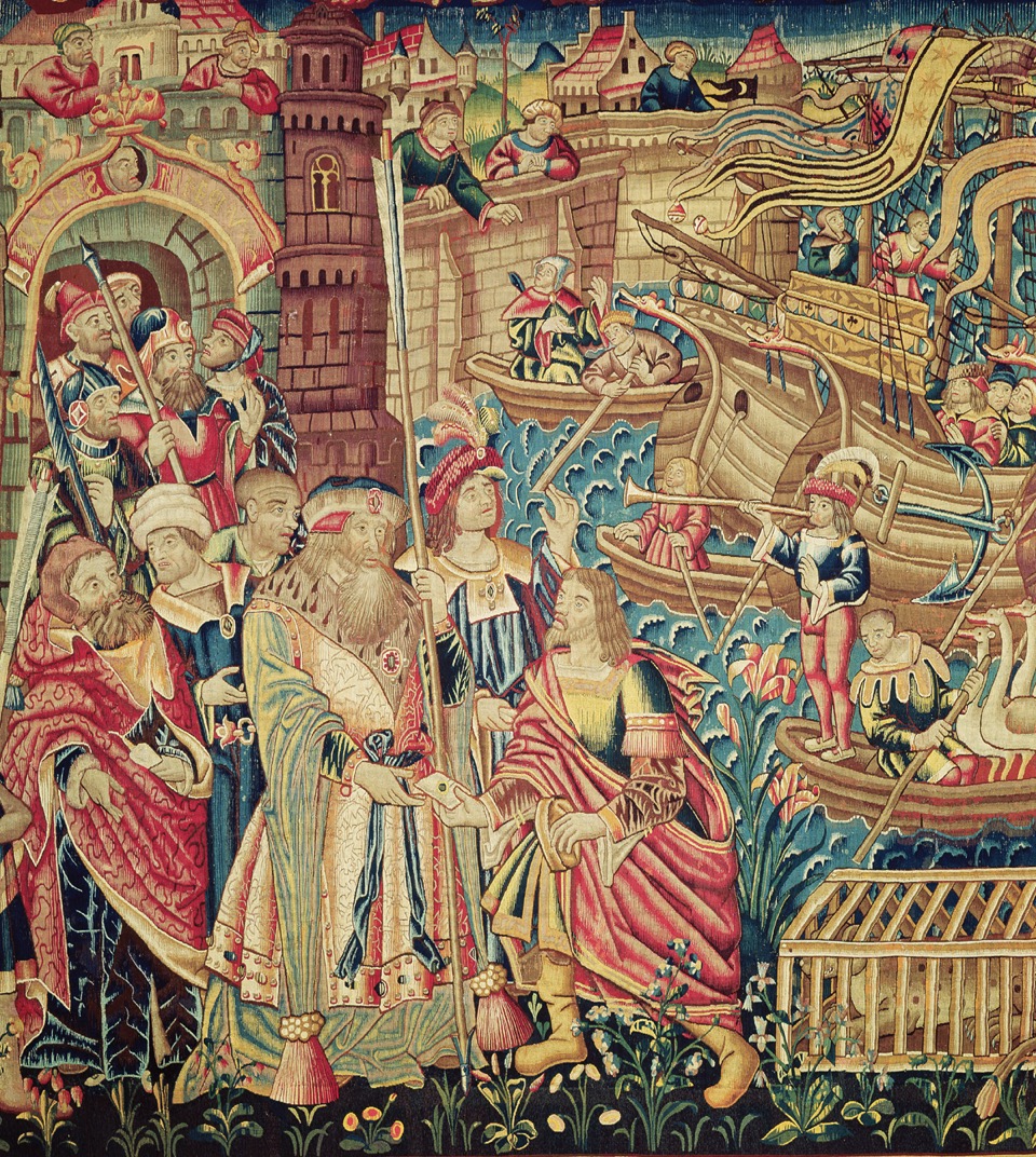 A tapestry shows Da Gama at the front center, holding a long staff and receiving a letter from one of his men, on the port.