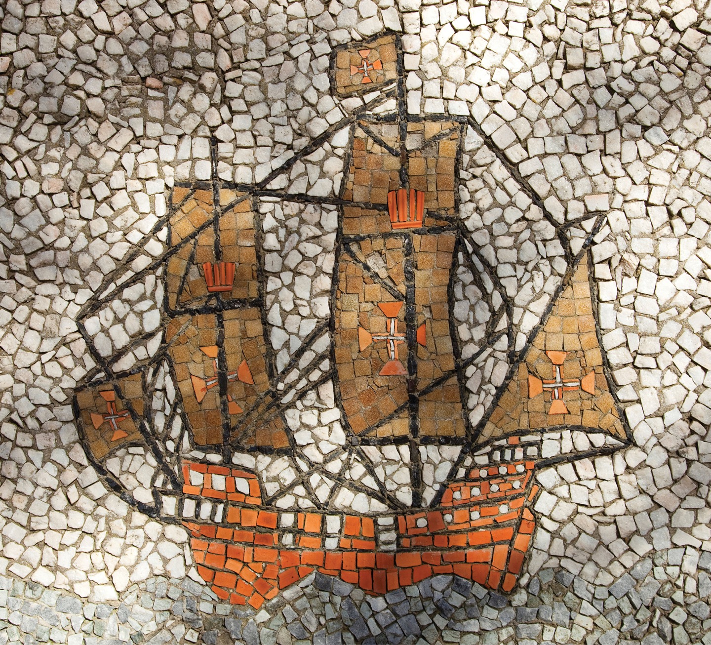 A photo shows a mosaic artwork of a sailing ship at sea.