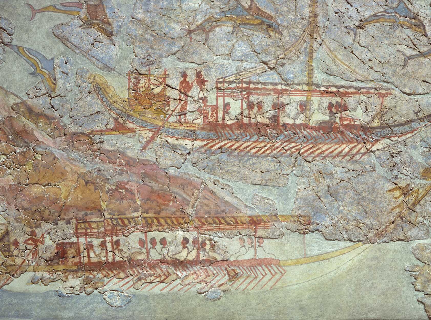 A painting shows two trade boats sailing. Dolphins are in the background.