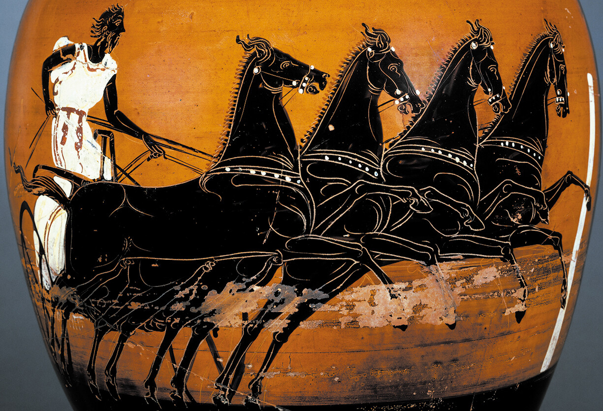 A Grecian vase depicting a charioteer riding a cart pulled by four horses.