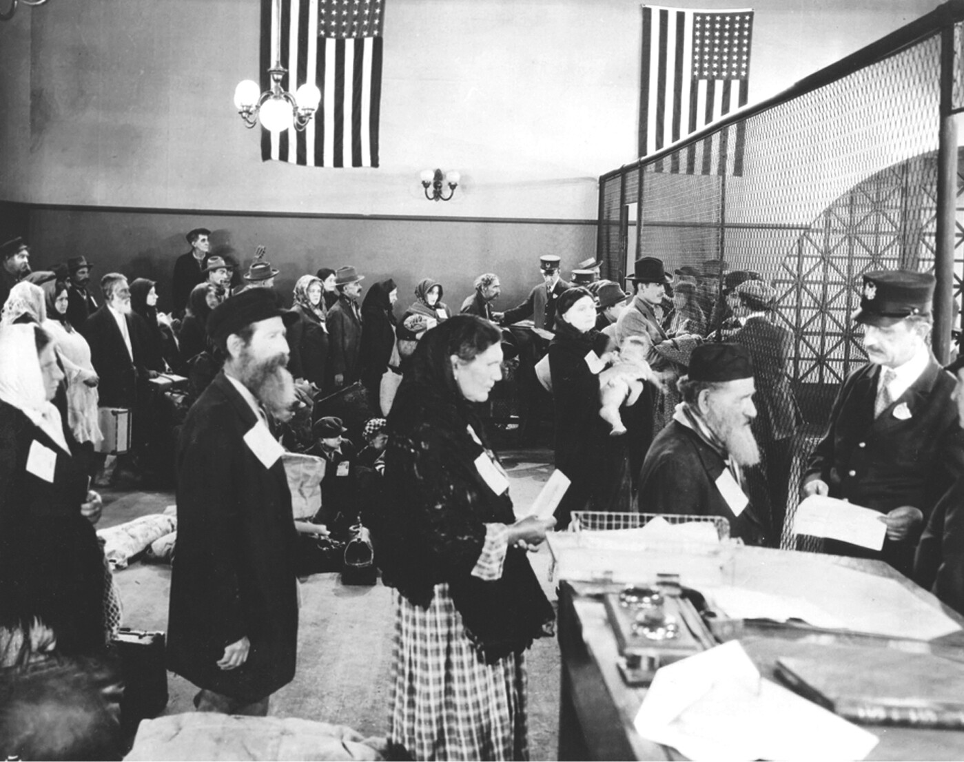 Lines of immigrants being processed in an immigration center during the 1900’s.