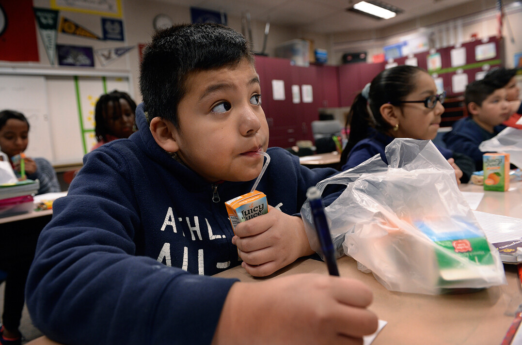 Children eating lunch in a classroom.