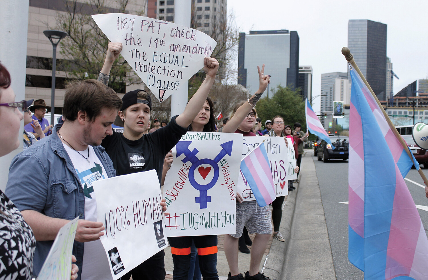 Young protesters with the transgender flag and signs.
