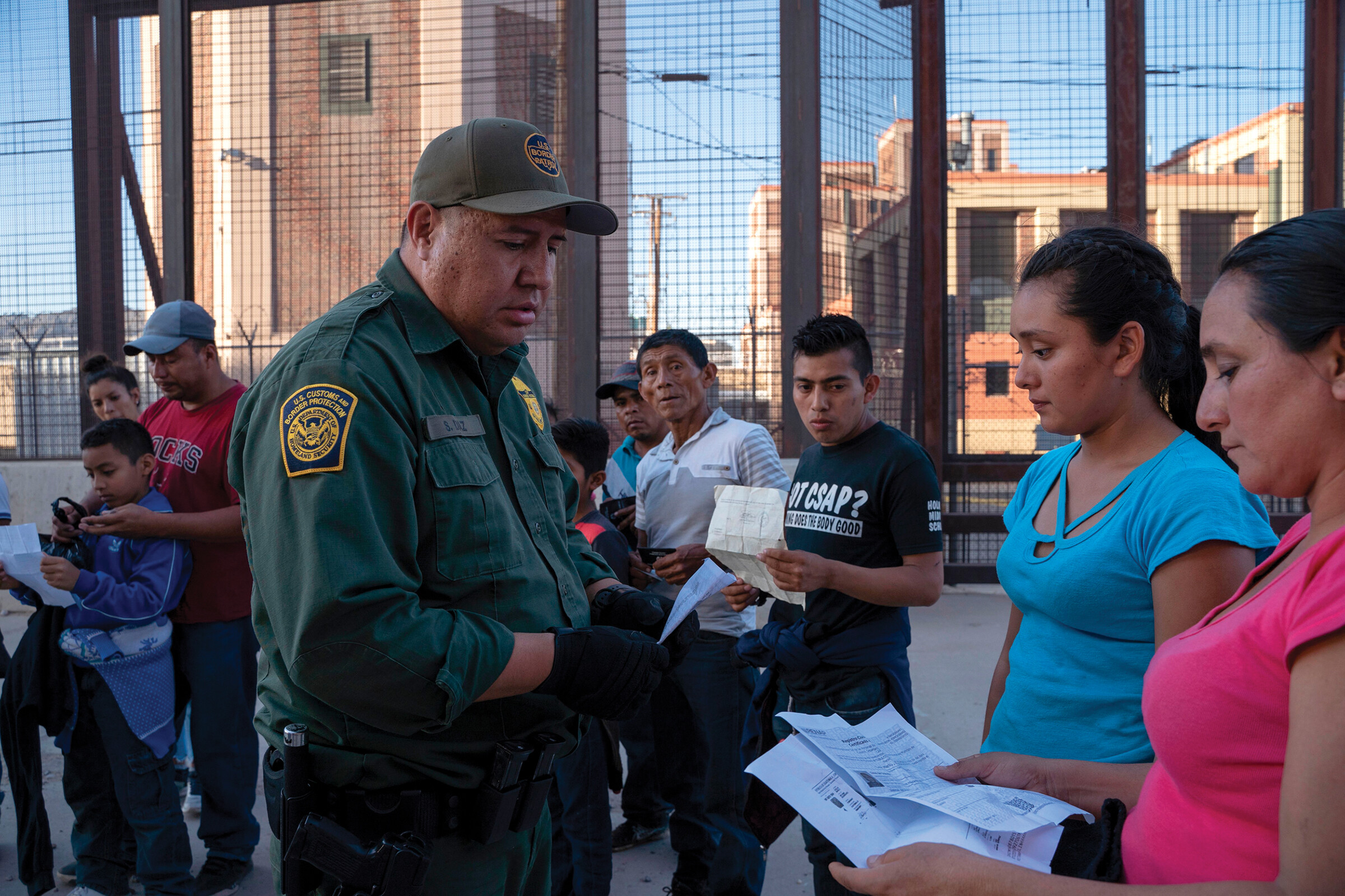 An immigration officer verifying the documents of a group of people.