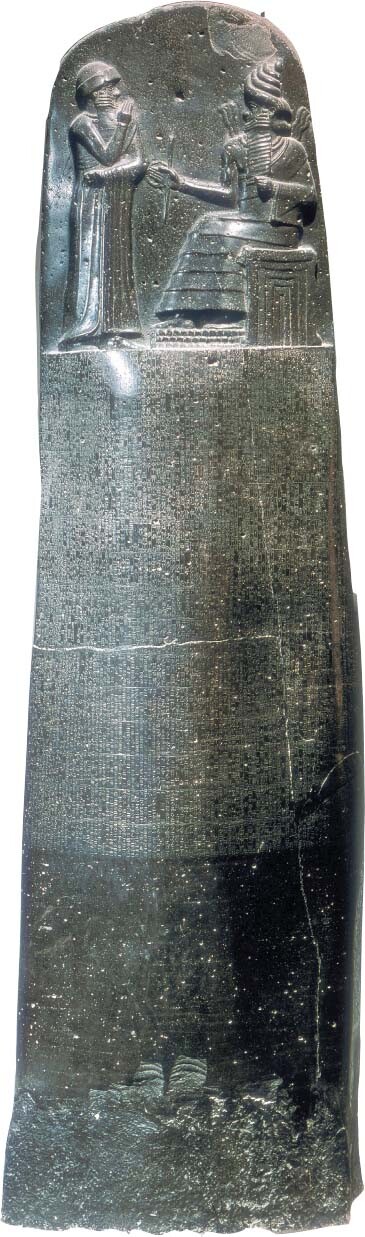 Hammurabi’s Code is inscribed on a stone shaft. A carving of two people is above the inscription.