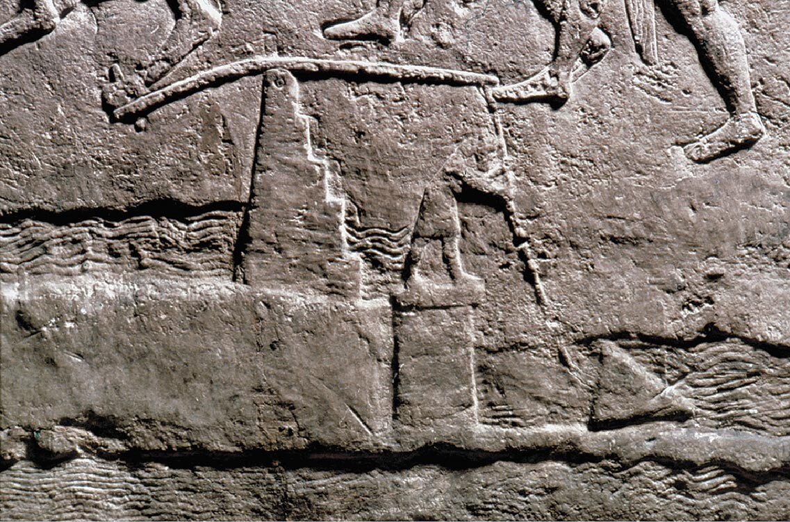 A stone carving of a man directing water through an aqueduct.
