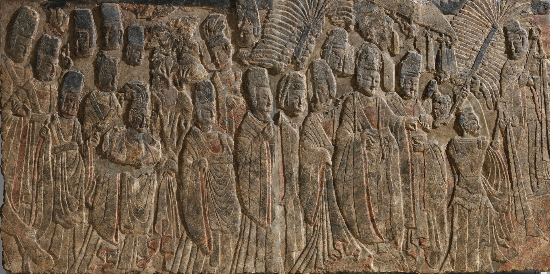 A carved stone relief from the Longmen Caves shows Emperor Xiaowen walking in a formal procession with members of his court.